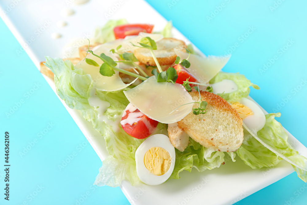 Plate with fresh Caesar salad on color background, closeup