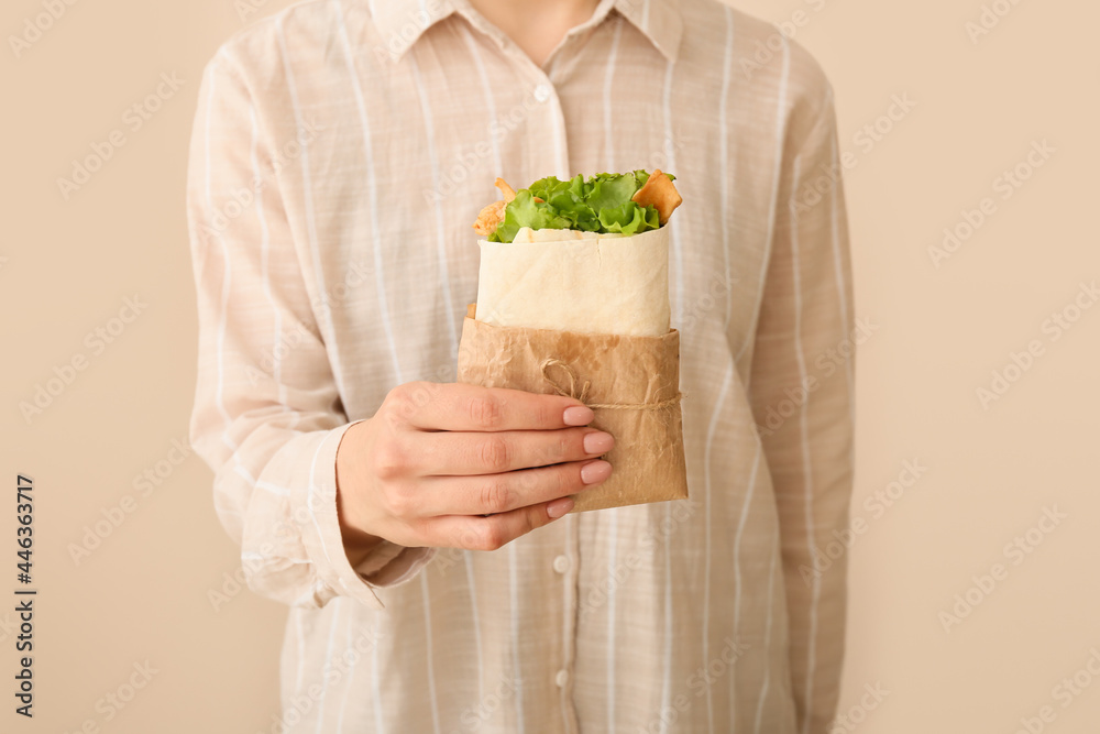 Woman with tasty doner kebab on color background