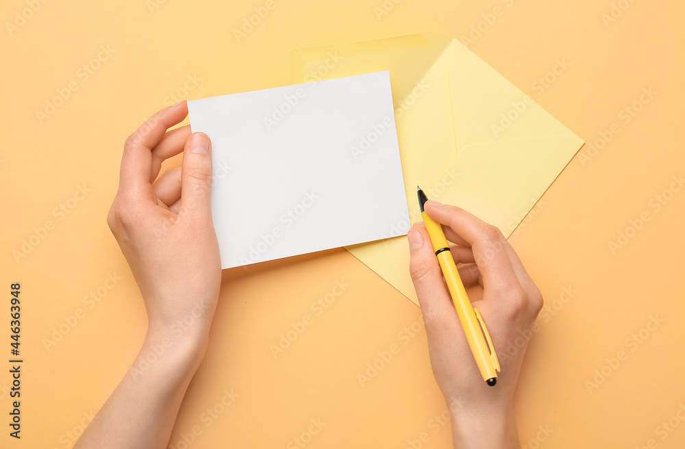 Female hands with blank sheet of paper, envelope and pen on color background