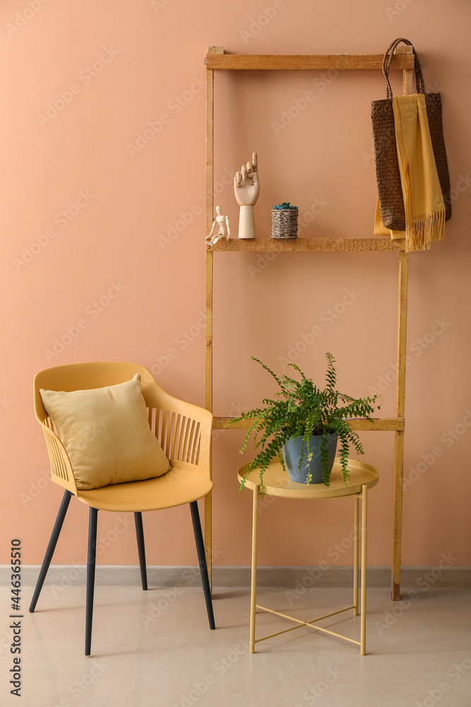 Interior of modern stylish room with armchair, table and shelf unit