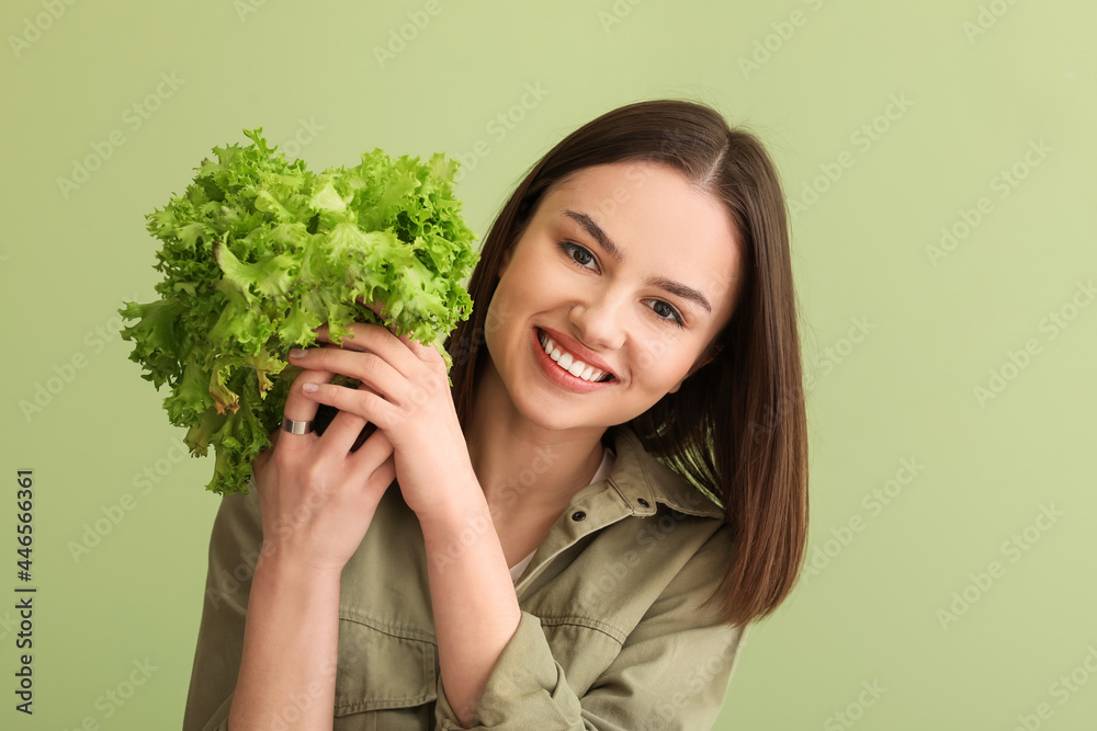 彩色背景上有新鲜生菜的年轻女人