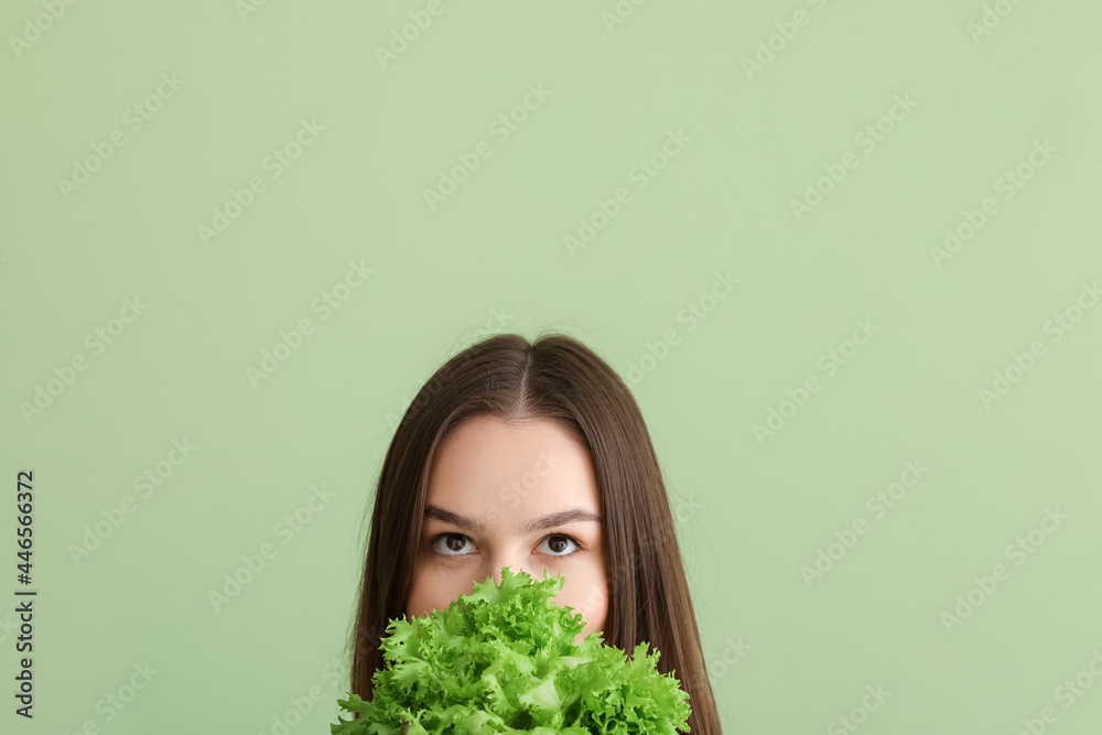 彩色背景上有新鲜生菜的年轻女人