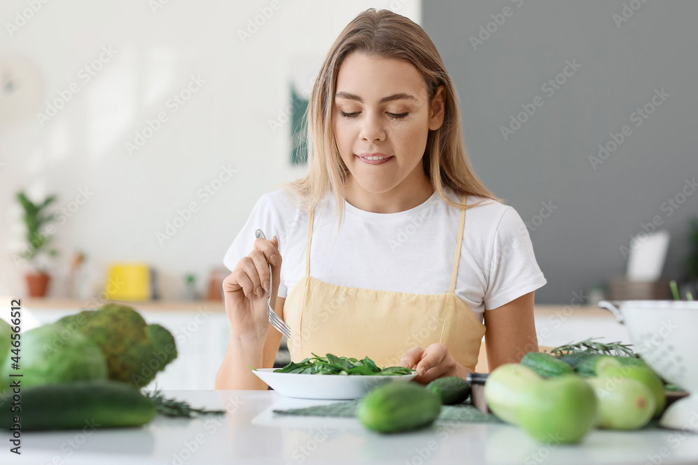 年轻女子在厨房吃新鲜沙拉