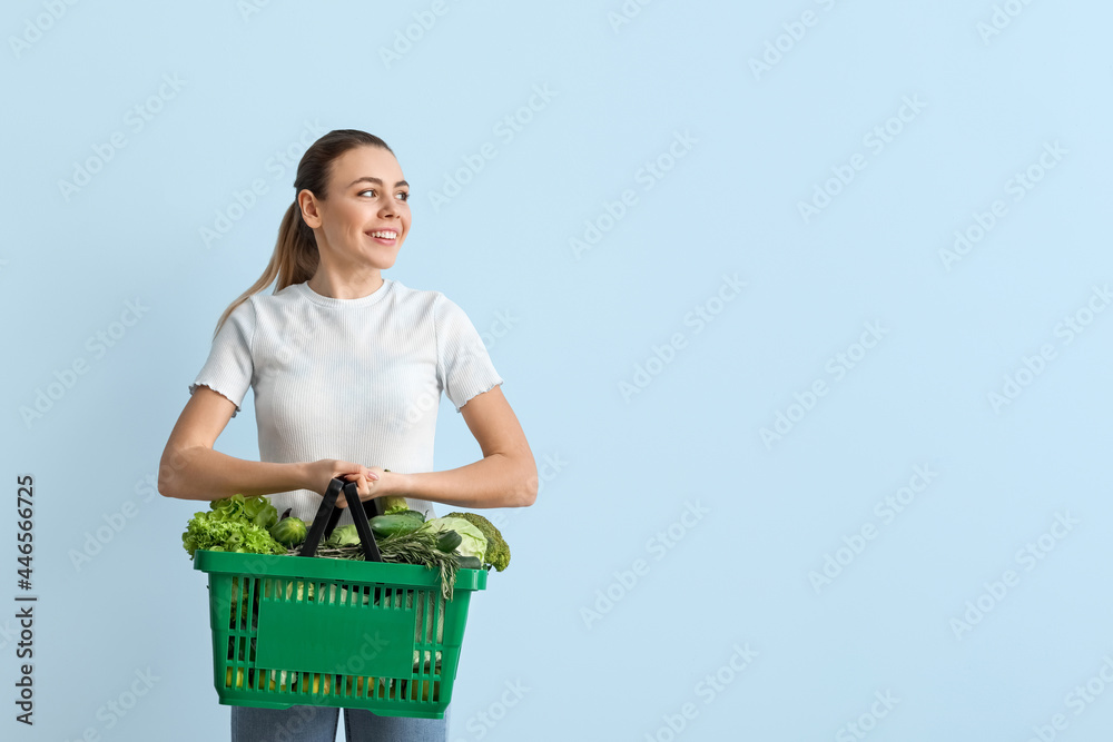 年轻女人和购物篮，背景是新鲜蔬菜