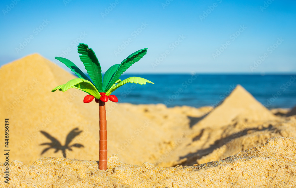 Miniature palm and two pyramids of sand close-up