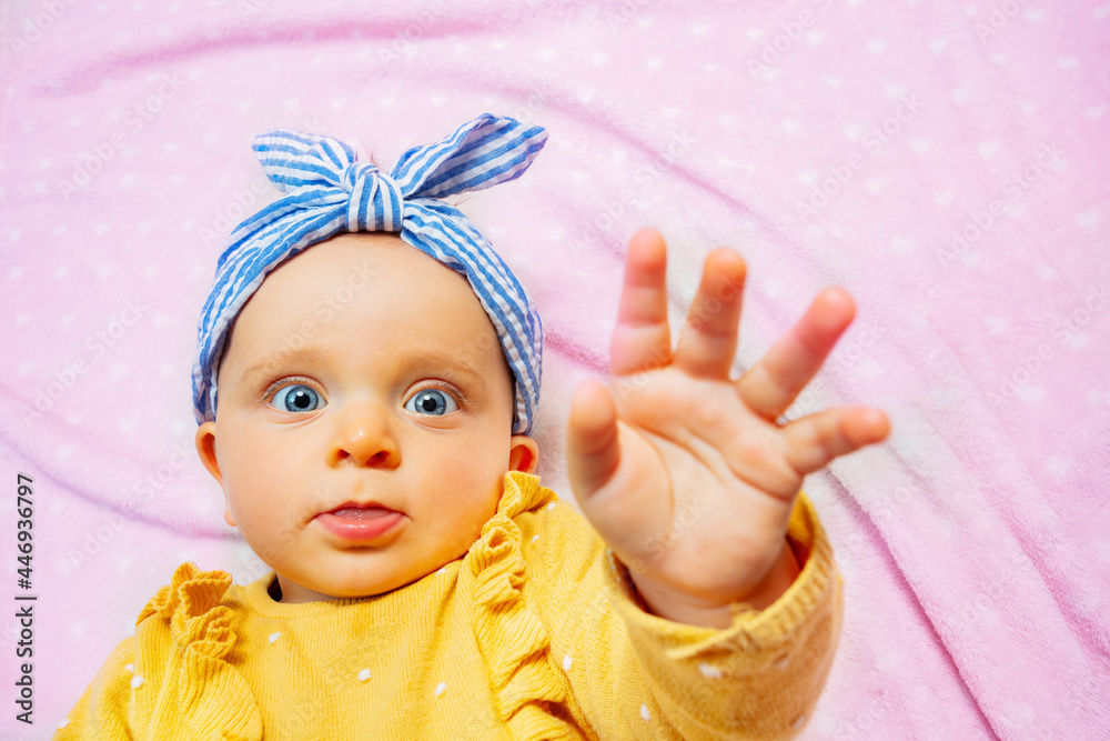 Baby lift up palm reaching with hand stop gesture