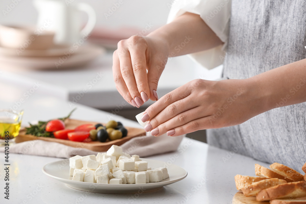 一位女士在餐桌上为美味的羊乳酪添加香料