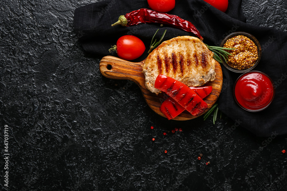 Board with tasty grilled pepper and steak on dark background