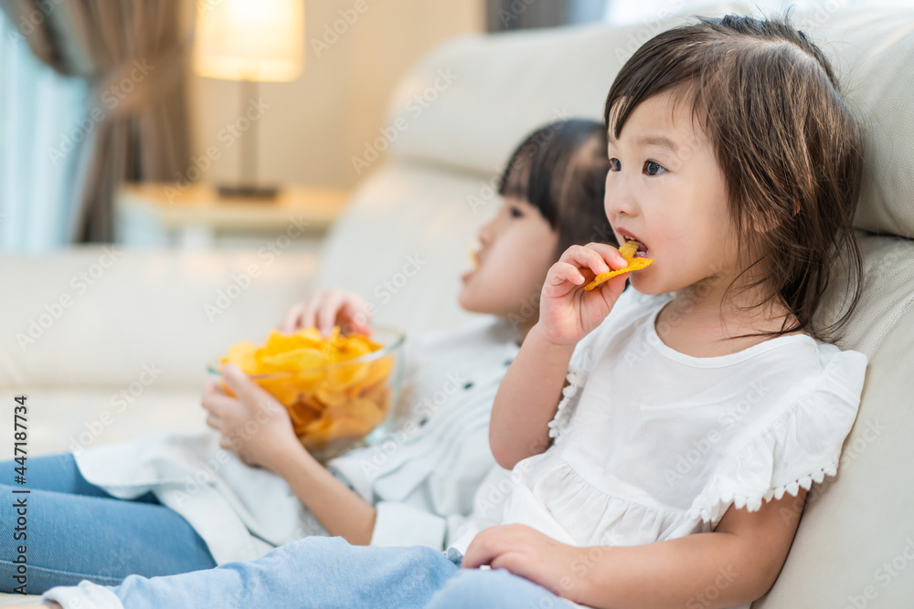 亚洲饥饿的小女孩兄弟姐妹用手把零食放进嘴里