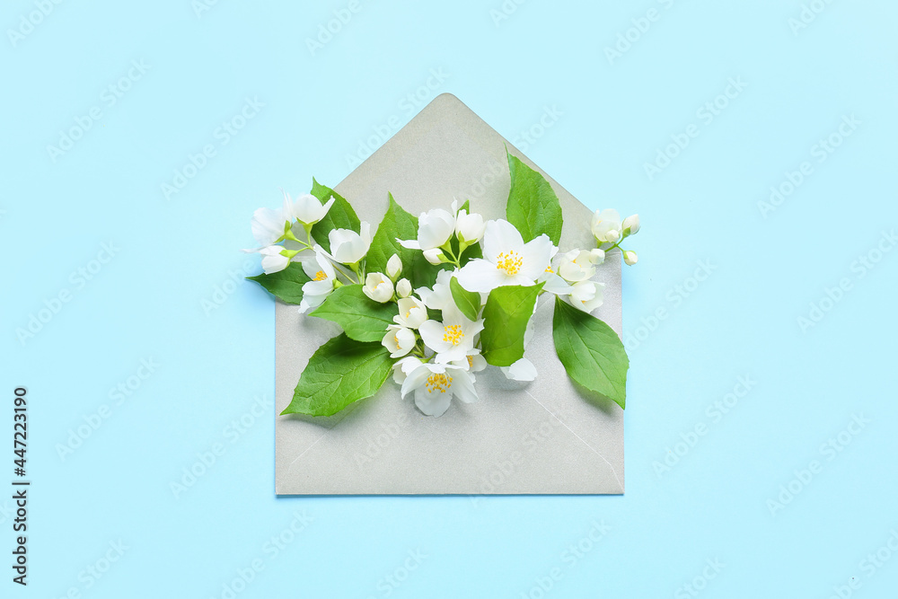 Envelope with beautiful jasmine flowers on color background