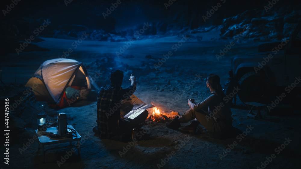 Happy Couple of Hikers Camping in the Canyon at Night Together, Sitting by Campfire, Plan Hiking Tre