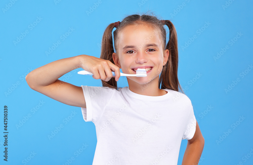 Little lovely girl with two cute ponytails posing with toothbrush and toothpaste on it