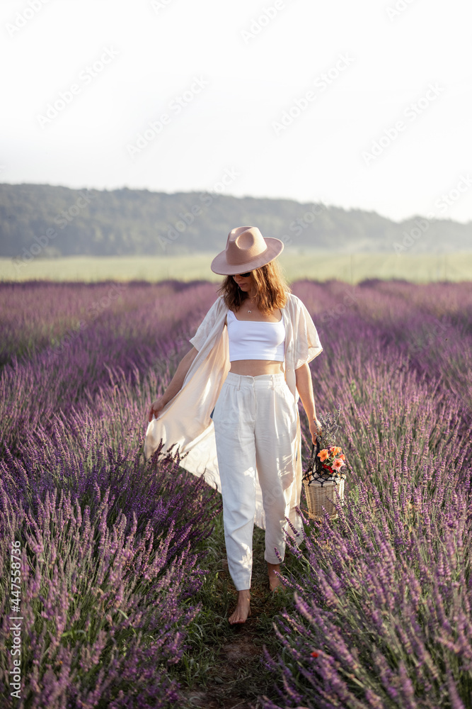 Young woman walking on lavender field with bouquet of violet flowers and enjoy the beauty of nature.