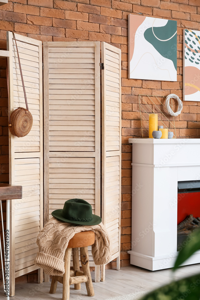 Interior of stylish room with fireplace and folding screen