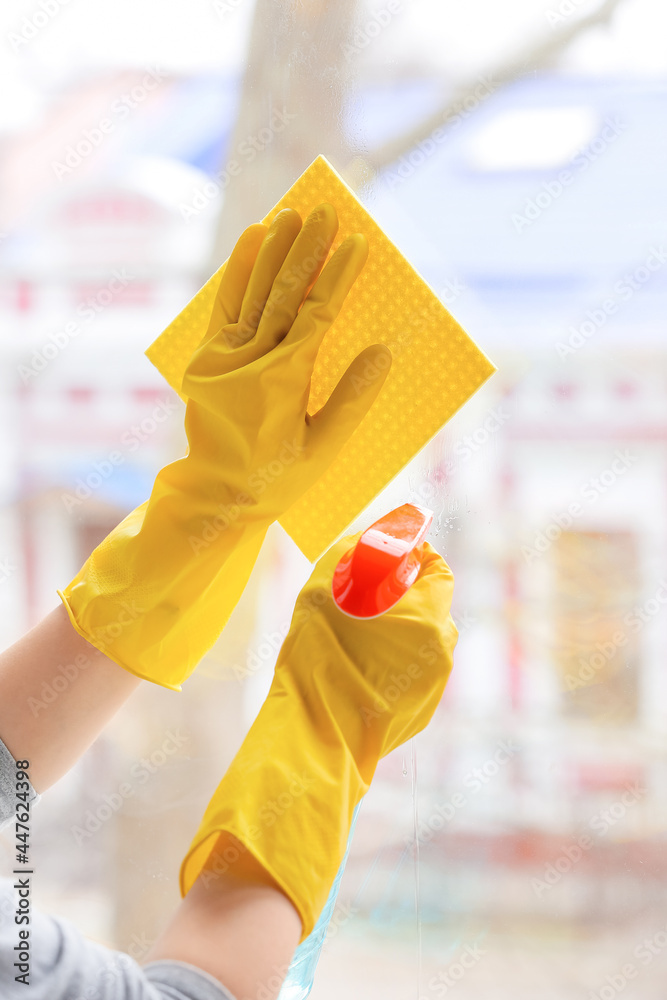 Woman cleaning window in room, closeup