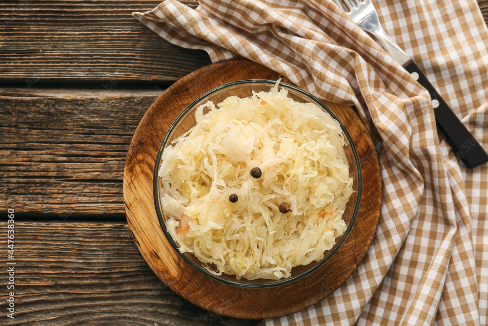 Bowl with tasty sauerkraut on wooden table