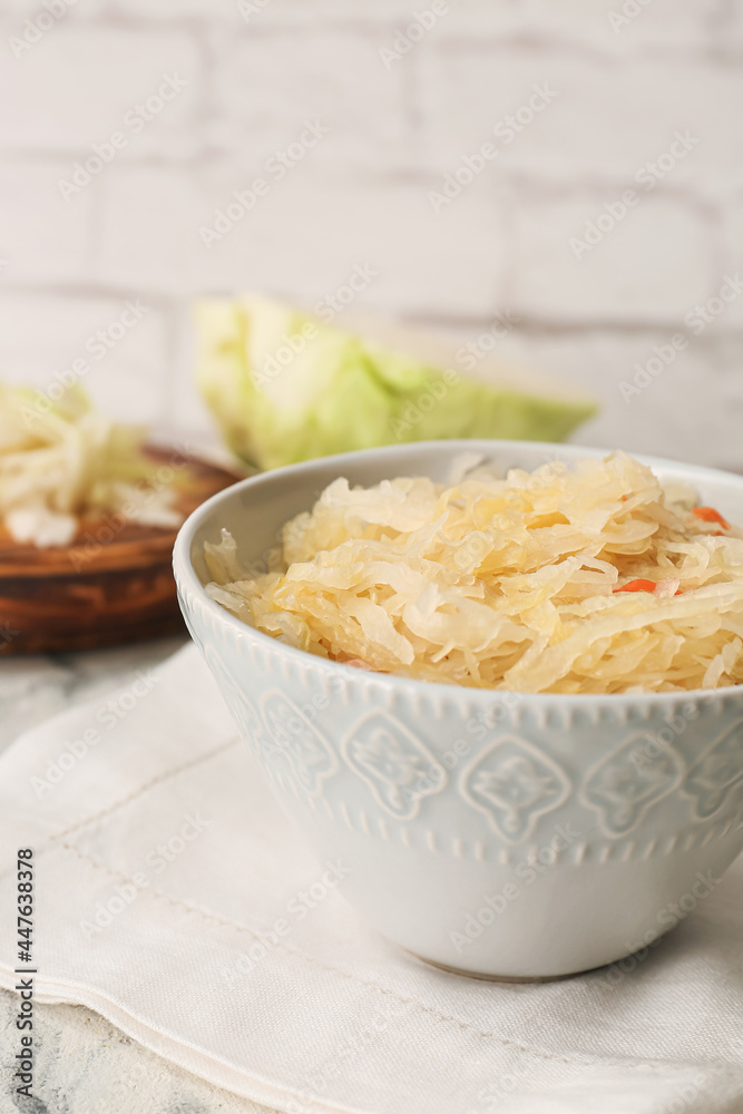 Bowl with tasty sauerkraut on light background