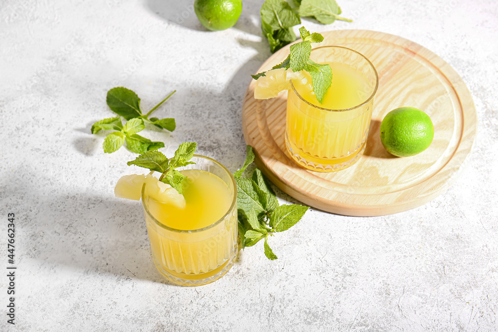 Glasses of delicious mai tai cocktail on light background