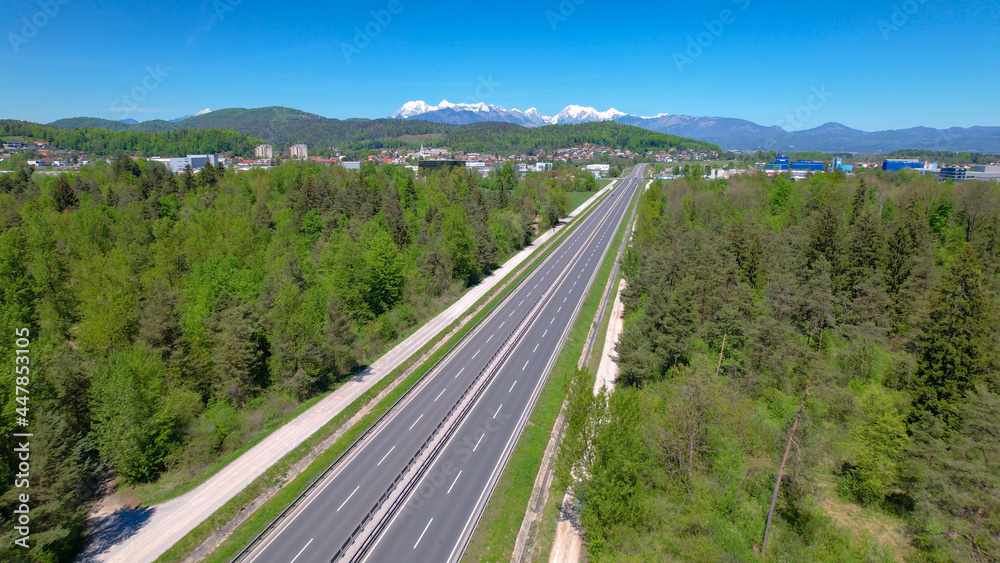 空中无人机拍摄高速公路穿越绿色景观并跑向郊区