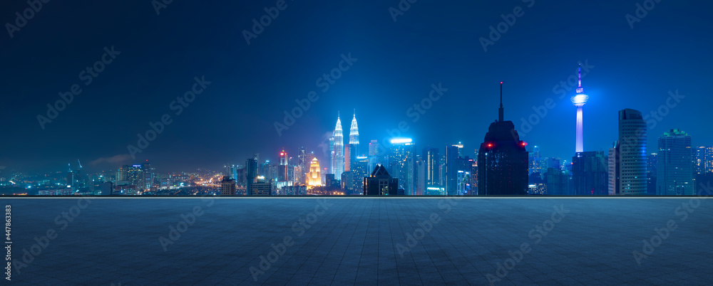 空旷的混凝土瓷砖地板与城市天际线的全景。夜景。