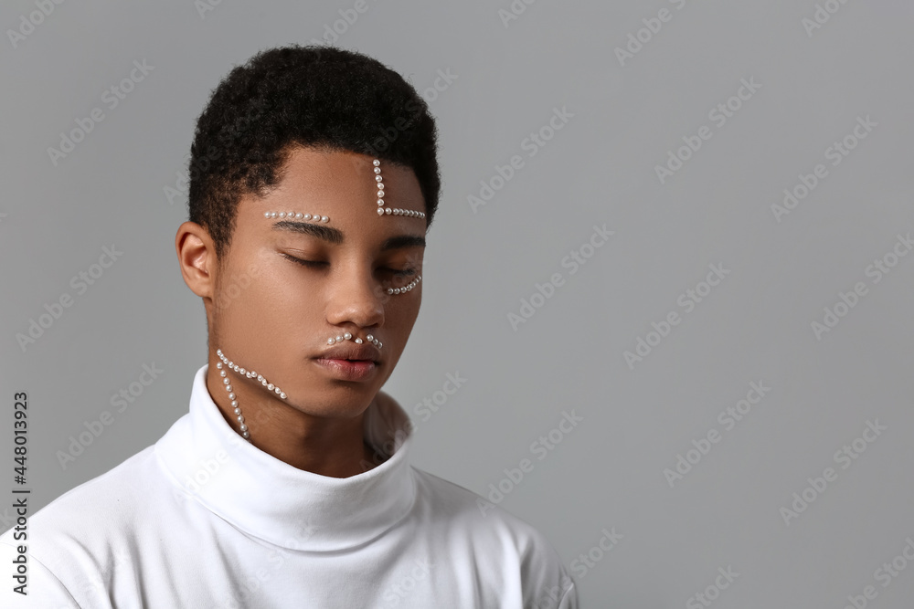 Creative portrait of handsome African-American guy on grey background