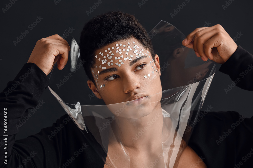 Creative portrait of handsome African-American guy on dark background