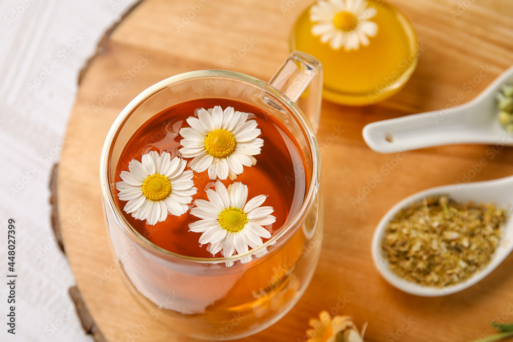 用一杯洋甘菊茶、花和蜂蜜在木背景上组成，特写