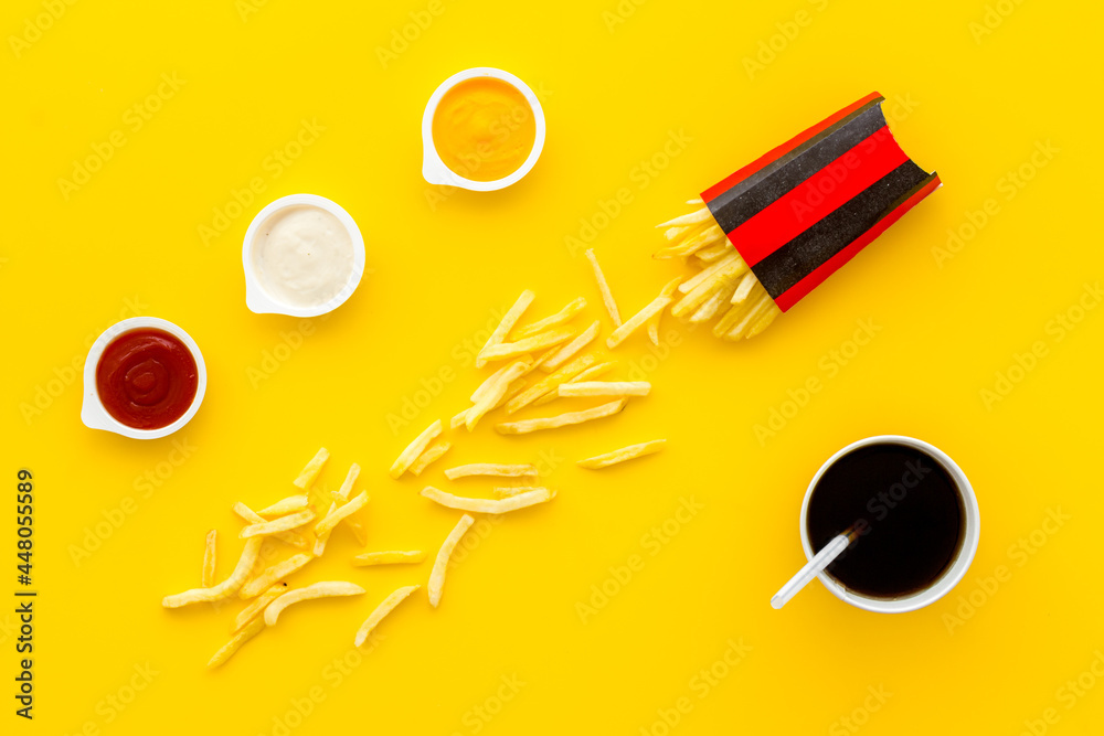 Patatoes french fries in red paper box with different sauces