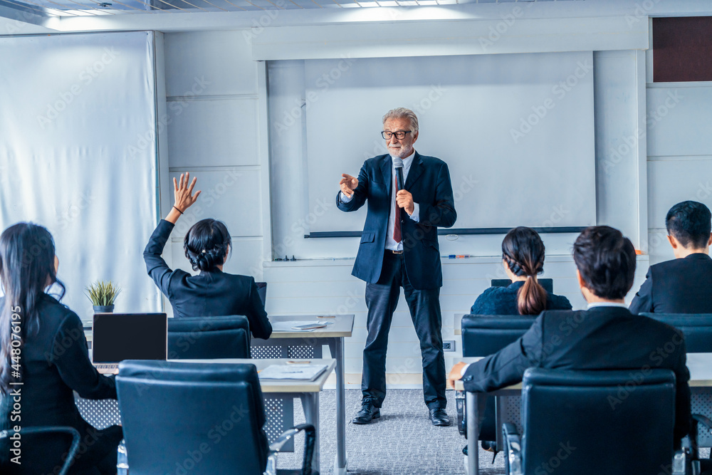 Senior leader speaker speaks to public people audience in training workshop or conference. Mature le