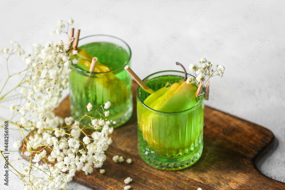 桌上有美味的鸡尾酒和美丽的吉普赛花的玻璃杯