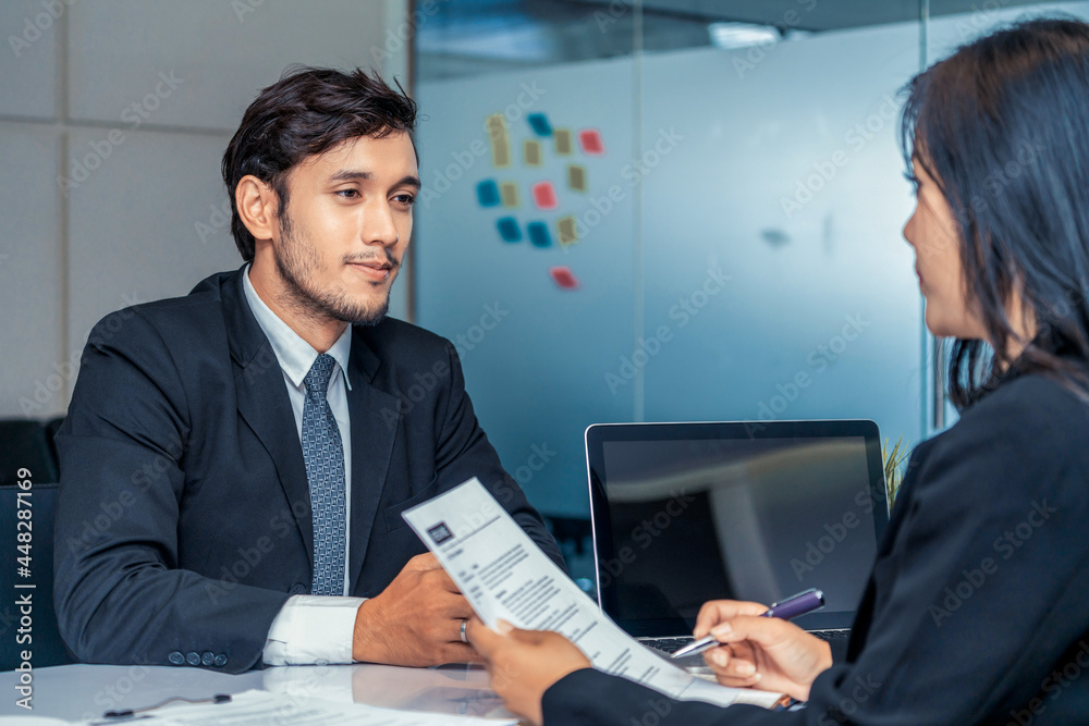 Human resource manager interviewing the male employment candidate in the office room. Happy job inte