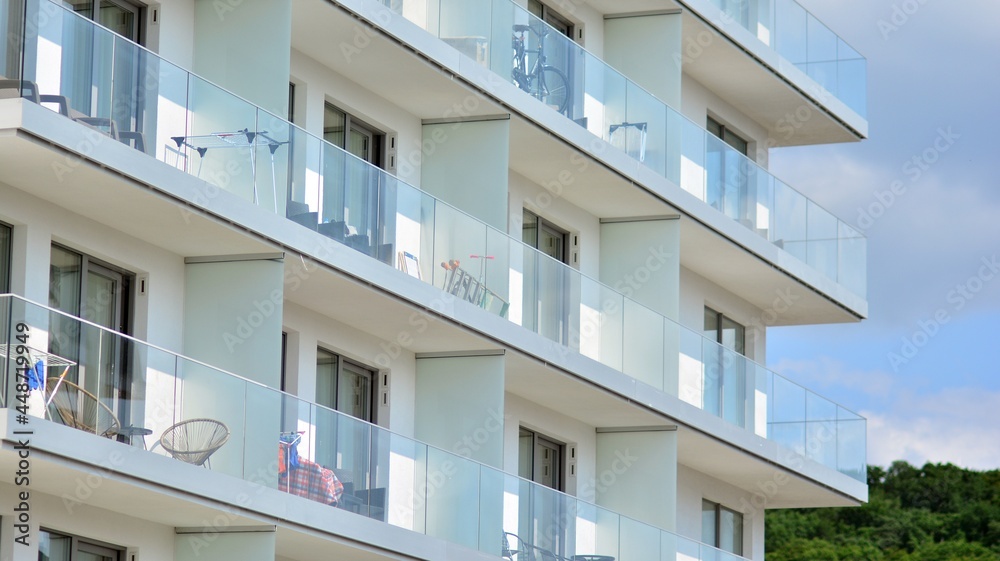 New apartment building with glass balconies. Modern architecture houses by the sea. Large glazing on