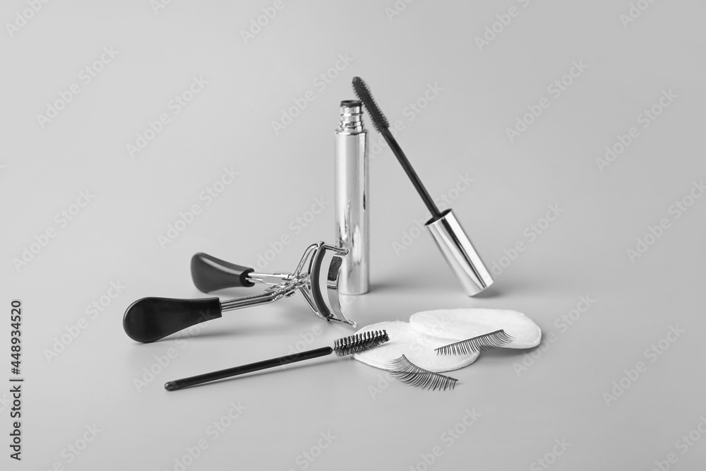 False eyelashes, mascara and tools on grey background