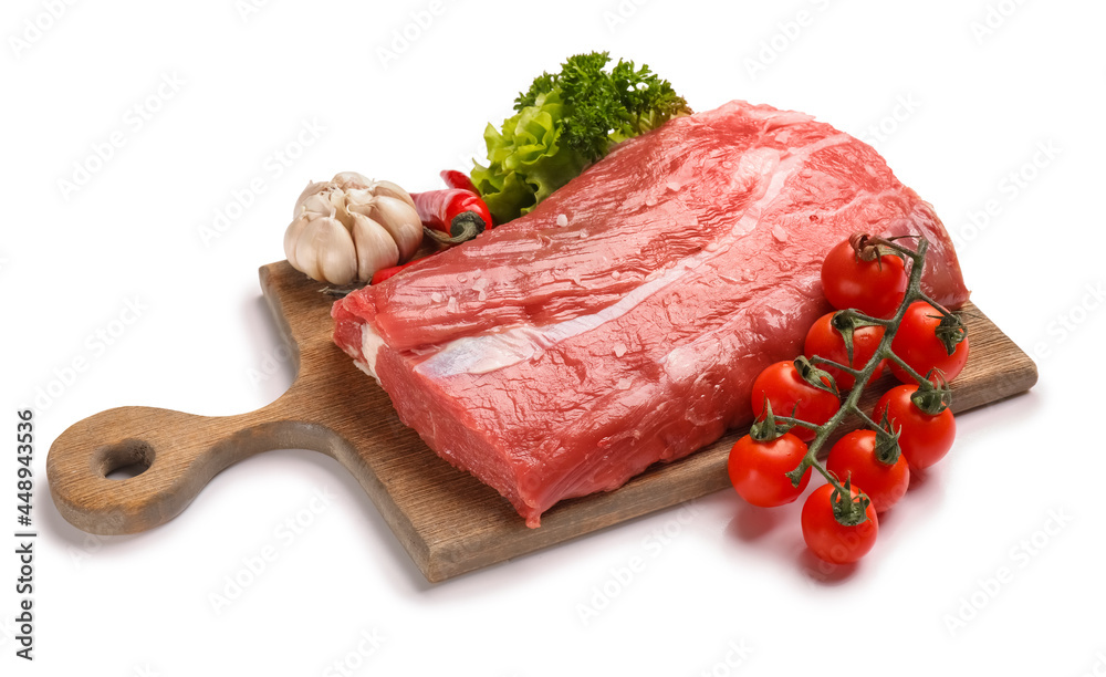 Wooden board with raw beef brisket and vegetables on white background