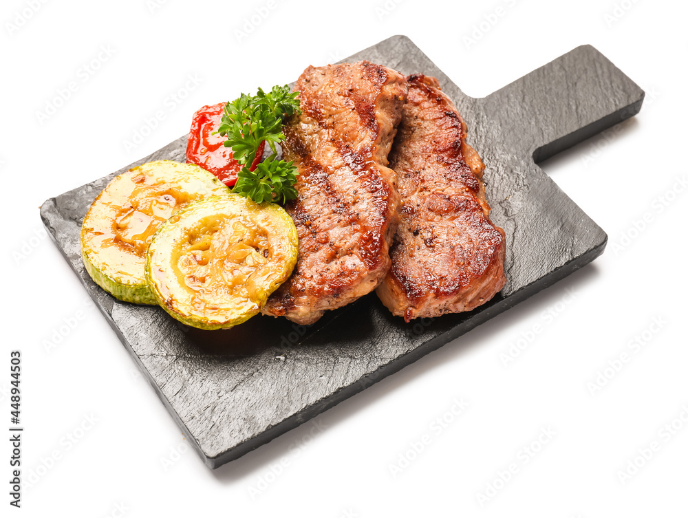 Board with tasty beef steaks and grilled vegetables on white background