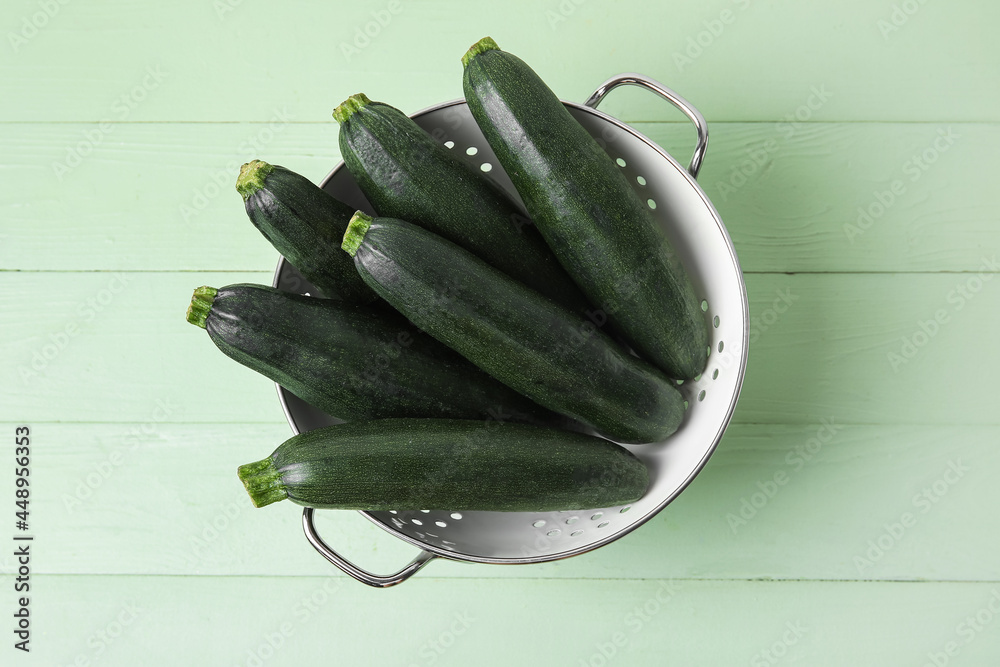 Colander with fresh zucchini squares on color wood background（在彩色木质背景上用新鲜西葫芦南瓜烹制的香菜）