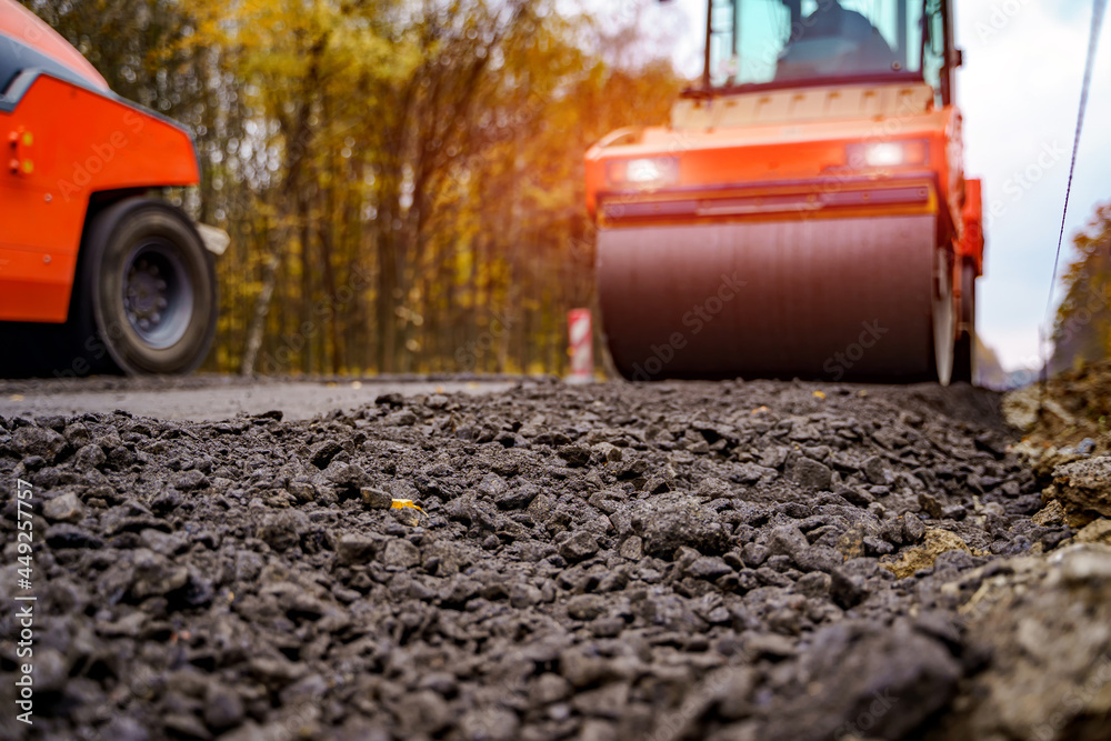 重型振动压路机在沥青路面工程中的裁剪视图。道路修复概念。焦点