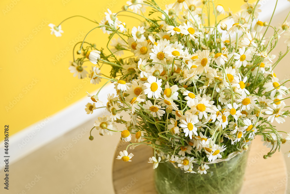 Vase with beautiful chamomiles on table, closeup