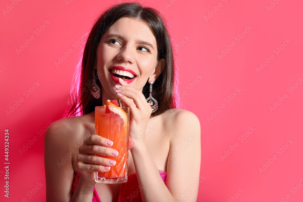 Beautiful young woman with cocktail on color background