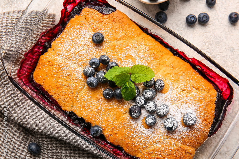 Baking dish with blueberry cobbler on light background, closeup