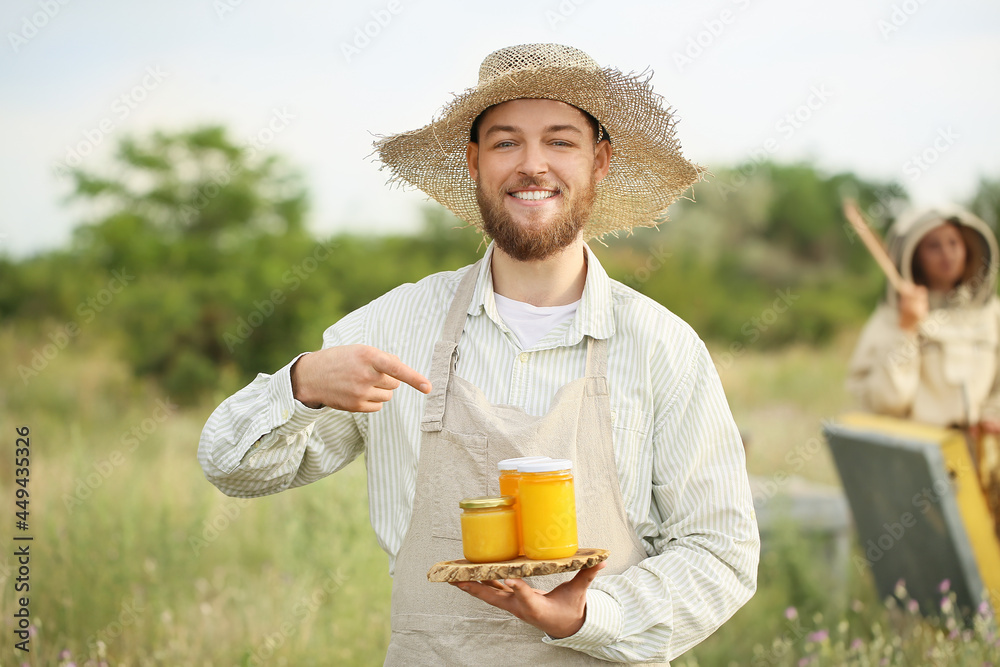 养蜂人在养蜂场用罐子装蜂蜜