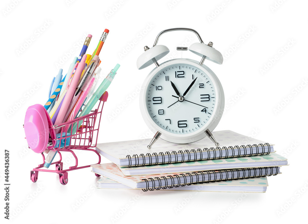 Shopping cart, alarm clock and stationery on white background