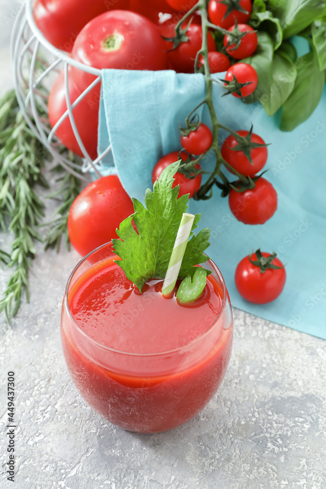 Glass of tasty tomato juice on light background