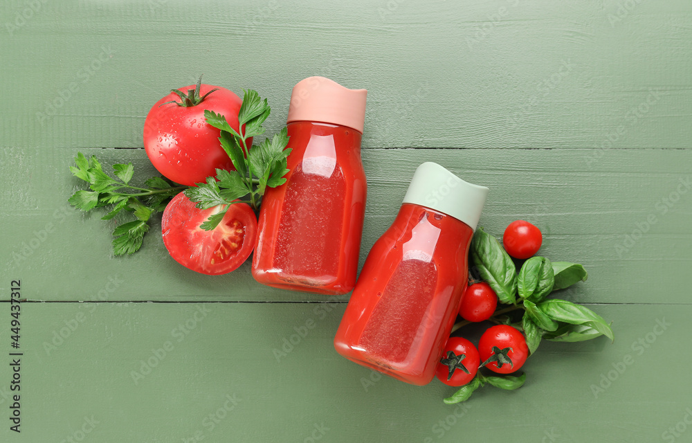 Bottles of tasty tomato juice on color wooden background