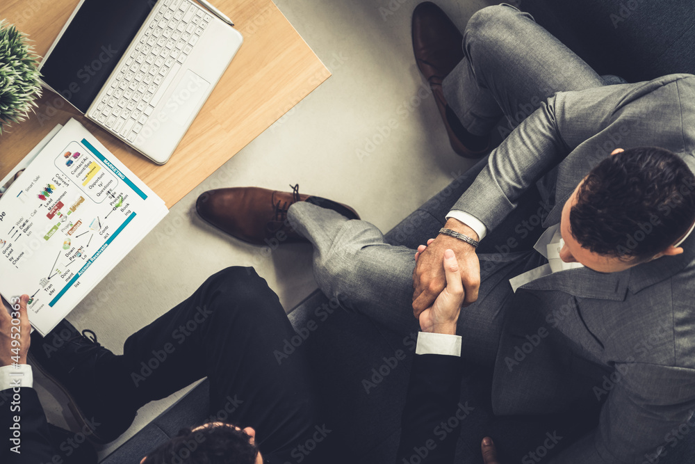 Businessman handshake with another businessman partner in modern workplace office. People corporate 