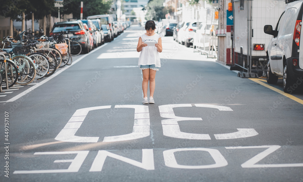 Asian Child is watching the phone on the road crossing or using a mobile phone for a long time hurts