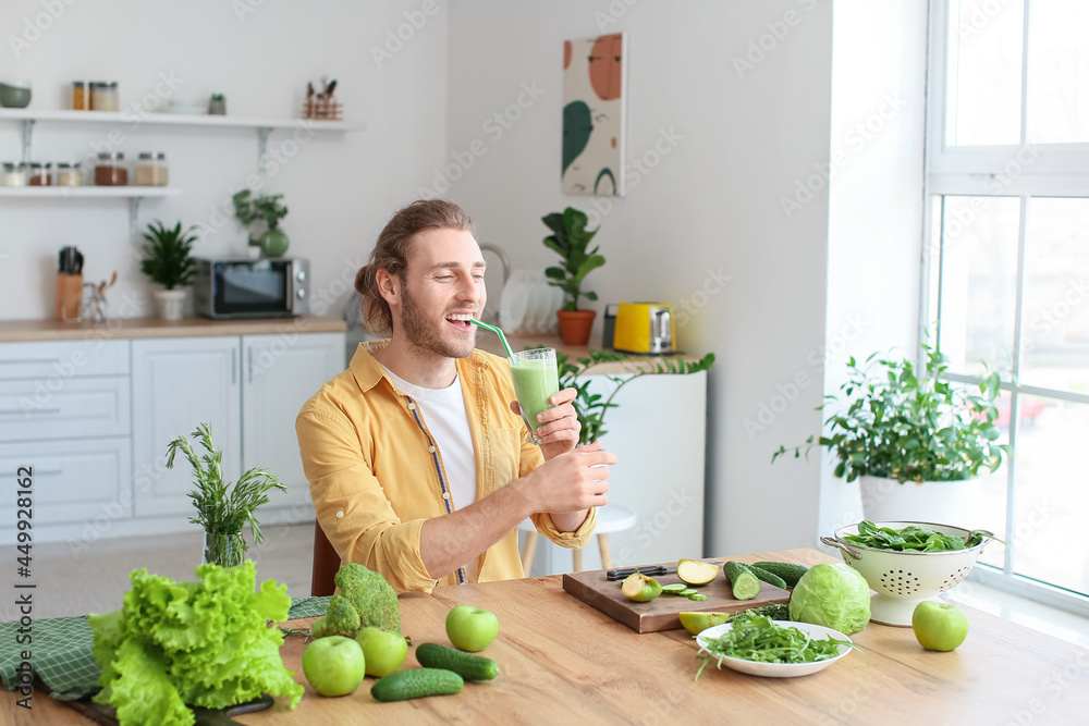 年轻人在厨房喝健康的绿色奶昔