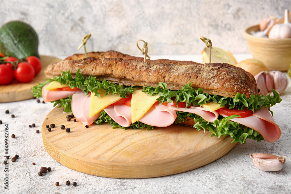 Board with tasty ciabatta sandwich on light background, closeup