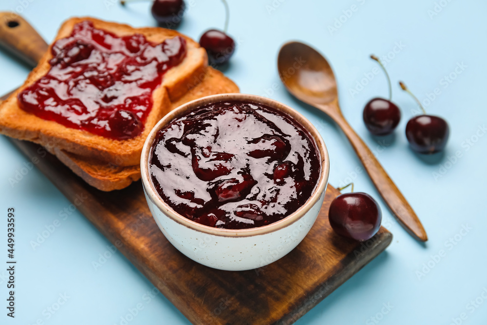 Bowl and toasts with cherry jam on color background