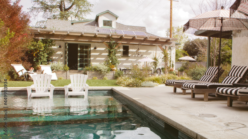 Wooden seats by a pool with parasols